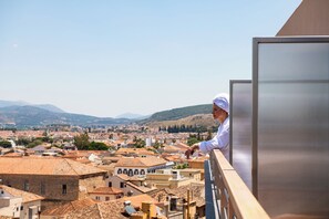 A balcony overlooking a town with traditional buildings and mountains in the background. - Naus Hotel (Nafplio)