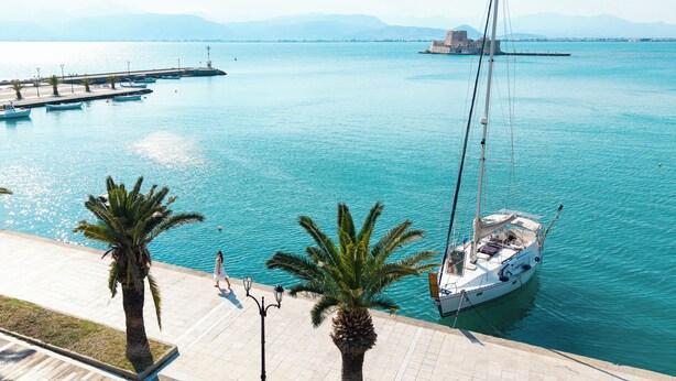 A marina with boats, a dock, and a coastal view. - Naus Hotel (Nafplio)