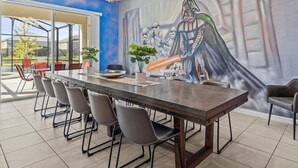 A conference room with a long table, chairs, and a mural of a character holding a lightsaber.