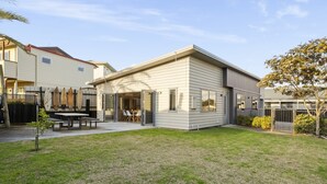 A modern two-story house with a patio and a dining area. - Sandy Feet Retreat - Papamoa (Papamoa)