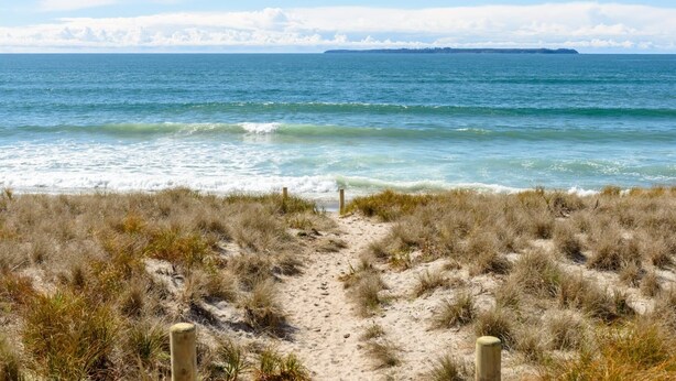 A beach path leading to the ocean with a clear view of the sea and distant land. - Sandy Feet Retreat - Papamoa (Papamoa)