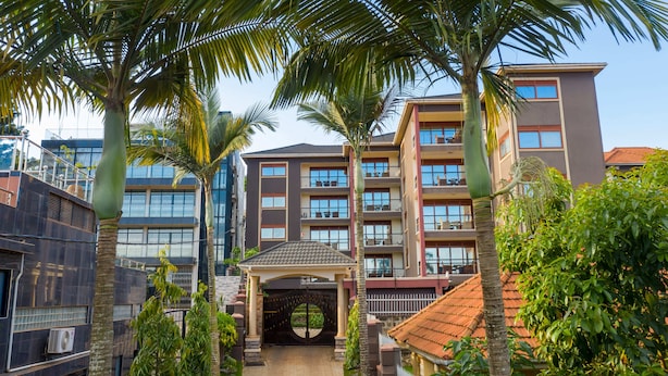 Un edificio de varios pisos con balcones, un patio central y abundante vegetación.