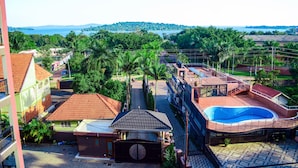 Zona residencial con piscina, entrada vigilada y vista a un lago y colinas.