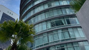 A modern, curved skyscraper with a glass facade and multiple floors. - Vortex Suites KLCC by Rit Villa (Kuala Lumpur)