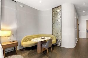 Um interior moderno com um sofá amarelo, uma mesa redonda e um painel decorativo.