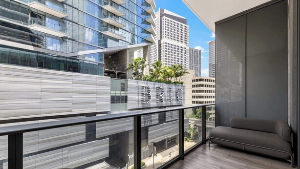Un balcon moderne avec un canapé, une table et une vue sur le paysage urbain.