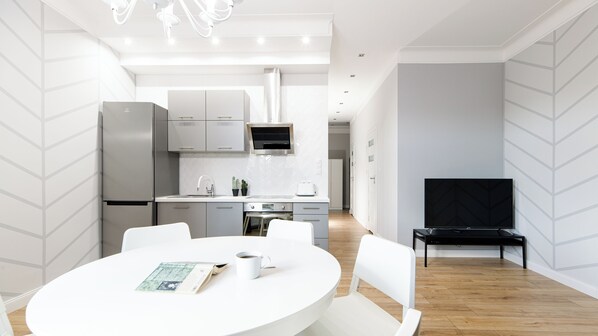 A modern kitchen with white cabinets, a built-in oven, and a microwave. - Native Apartments Blich 7 (Kraków)