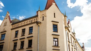 A historic building with a prominent corner tower and a red-tiled roof. - Native Apartments Blich 7 (Kraków)
