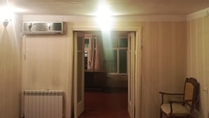 A room with a radiator, a chair, and an open door leading to another room. - Freestyle Hostel Baku (Baku)