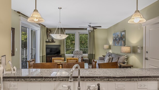 A kitchen with granite countertops, a stainless steel sink, and pendant lighting. - Grand Comfort: 2 BR w/ Golf Cart & Bay Views at Sandestin Golf and Beach Resort! (Miramar Beach)