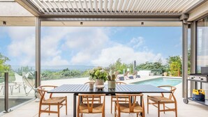 A rooftop terrace with a pool, dining table, and chairs, offering a view of the landscape. - Futuriste - Exceptional residence with panoramic view (Saint-Didier-au-Mont-d'Or)