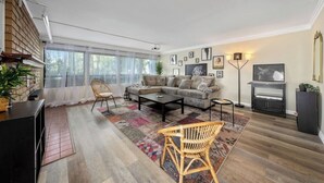 Un salon moderne avec un canapé d’angle, une table basse et une cheminée.