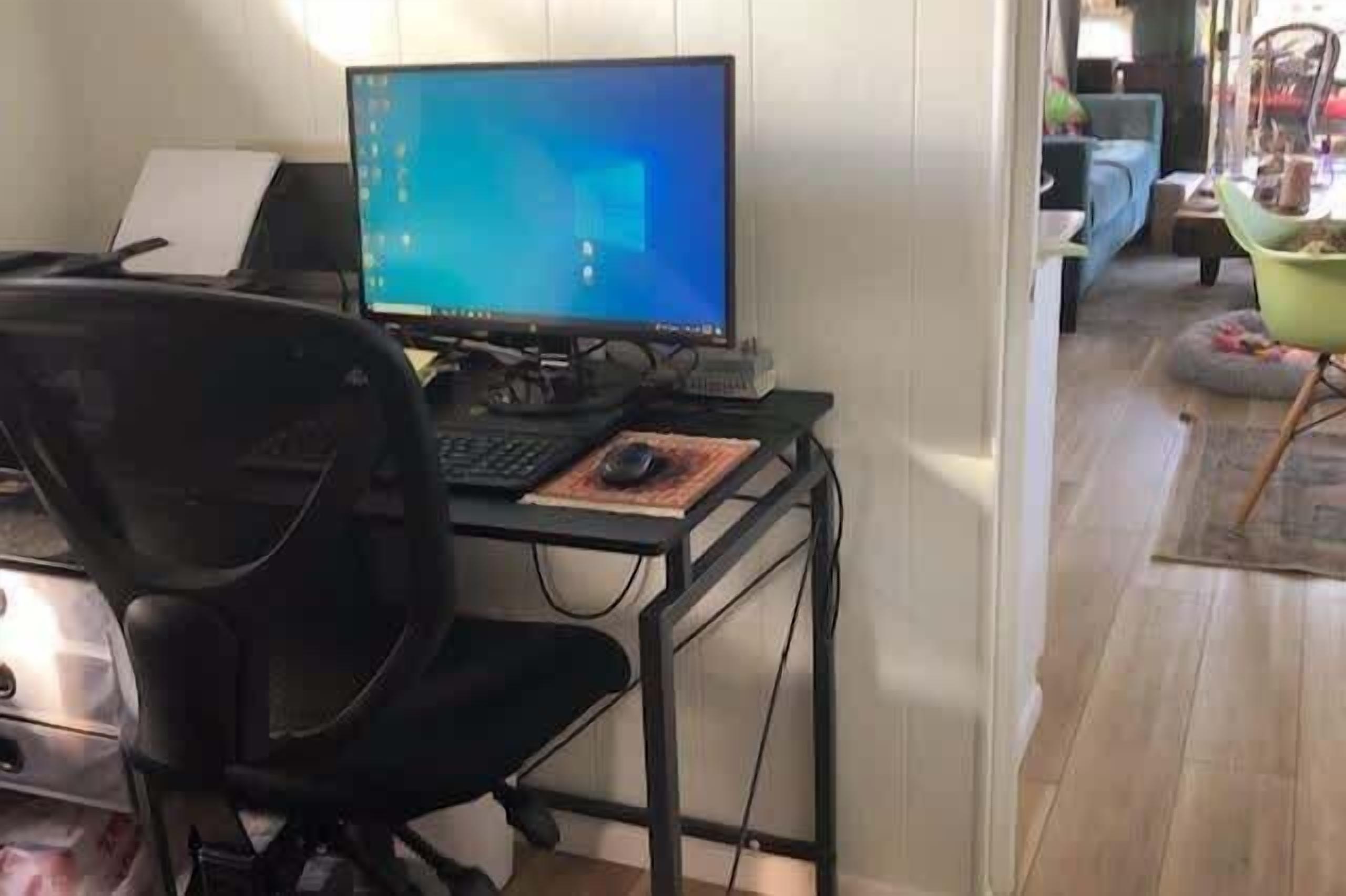 A home office setup with a computer, chair, and desk.