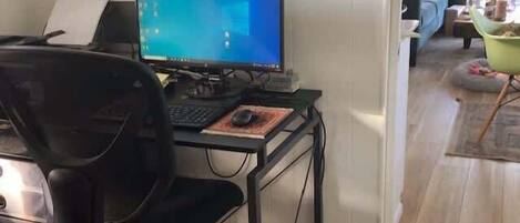 A home office setup with a computer, chair, and desk.