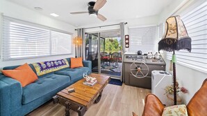 A living area with a sofa, coffee table, and a control panel, likely for a boat. - Pura Vida- Floating Home (Merritt Island)