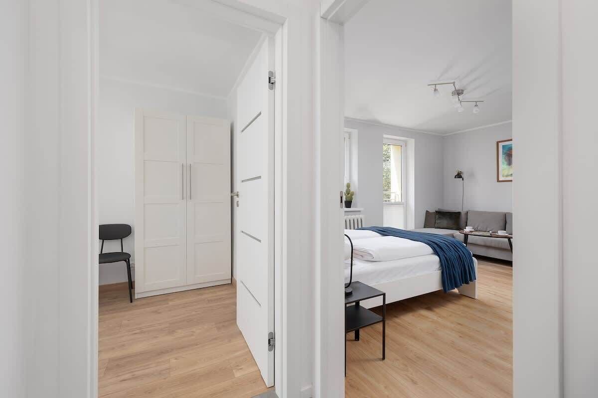 Een moderne slaapkamer met een bed, nachtkastje en een stoel.
