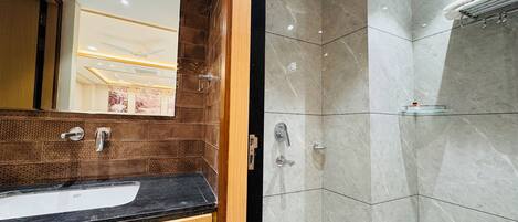 Ein modernes Badezimmer mit einem Holz-Waschtisch, einem großen Spiegel und einer Dusche mit Glastrennwand.