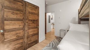 Ein Schlafzimmer mit einem Bett, einem Holzschrank und einem Flur, der zu einem Badezimmer führt.