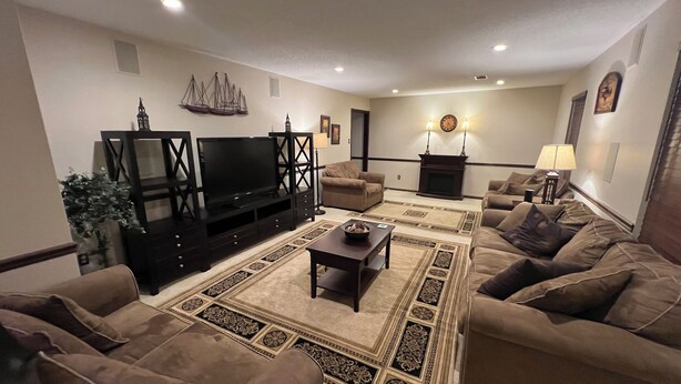 A living room with a TV, sofas, a coffee table, and a patterned rug. - Lakefront Home in Cabot (Cabot)