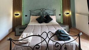 Une chambre à coucher bien aménagée, avec un lit, des tables de chevet et des lampes fixées au mur.