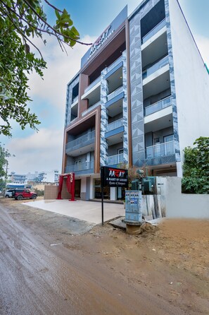 A multi-story building with a sign reading "AAGAT A Room of Luxury." - Aadat Hotel Near Artemis Hospital Gurgaon (Gurugram)