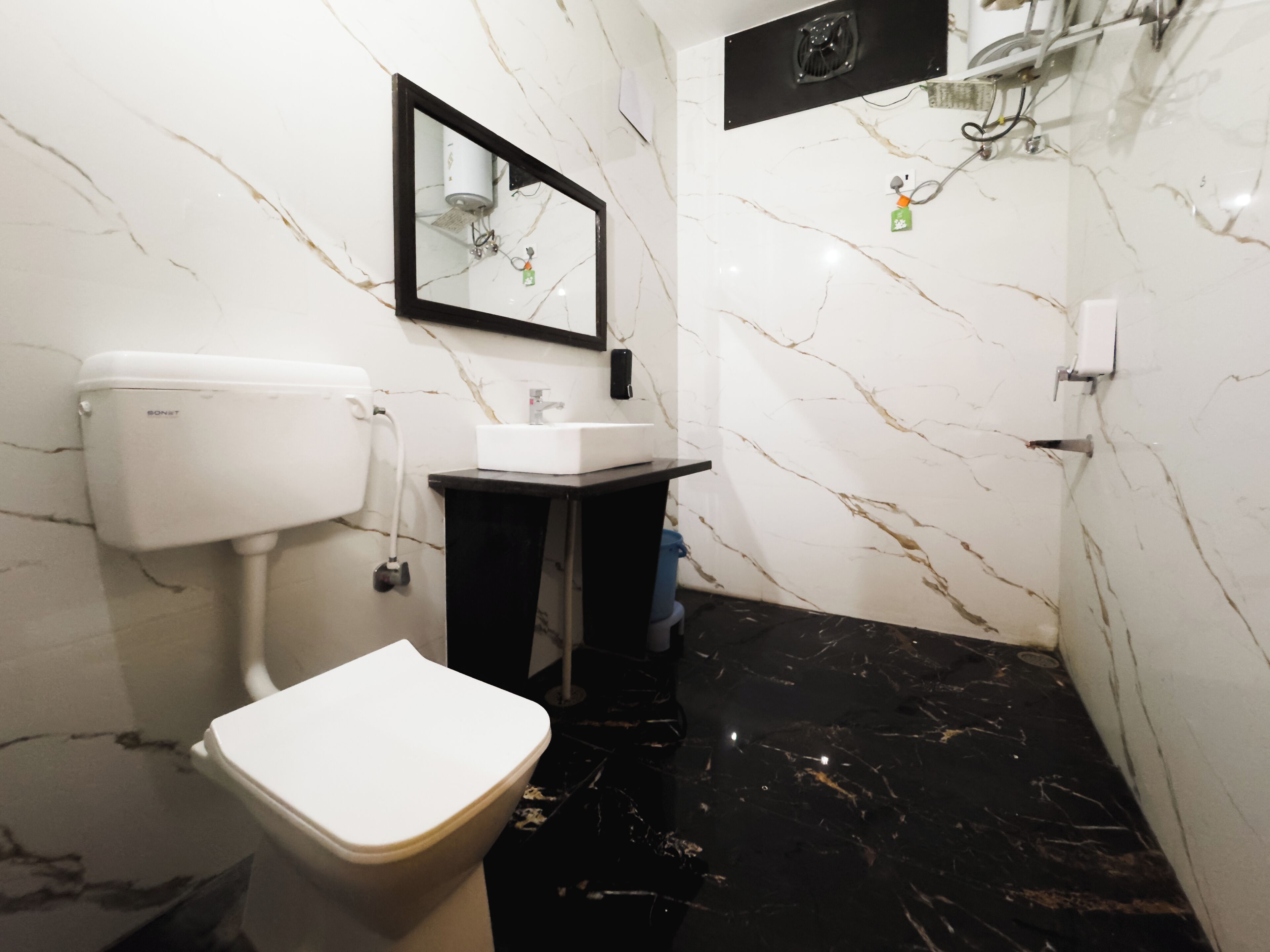 Ein Badezimmer mit Toilette, Waschbecken und Spiegel.