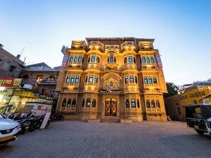 Traditional architecture meets modern charm at the Prince Hotel & Restaurant, featuring ornate railings and a grand entrance.