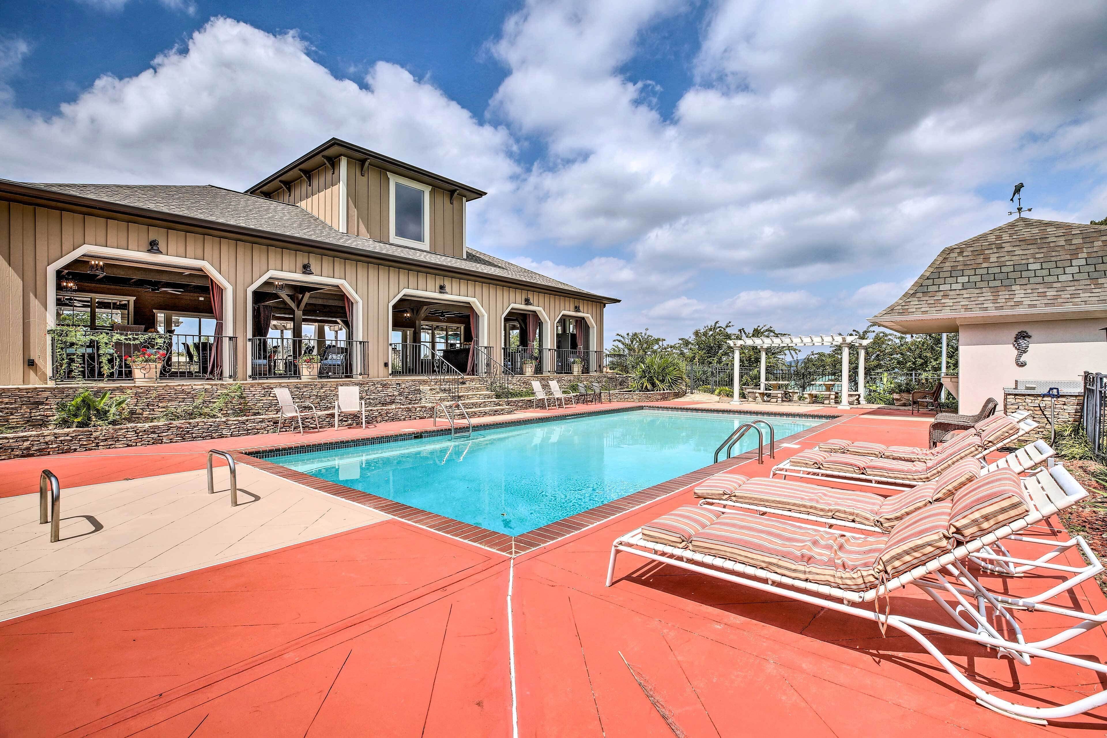 A swimming pool with lounge chairs and a covered patio area.