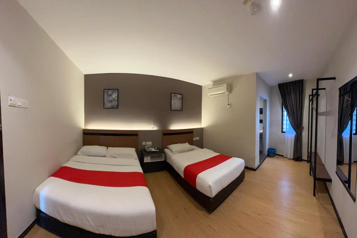 Ein Hotelzimmer mit zwei Betten, einem Nachttisch, einem Spiegel und einem Fenster mit Vorhängen.