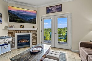 Ein Wohnzimmer mit Kamin, einem großen Gemälde und einem Balkon mit Sitzgelegenheiten.
