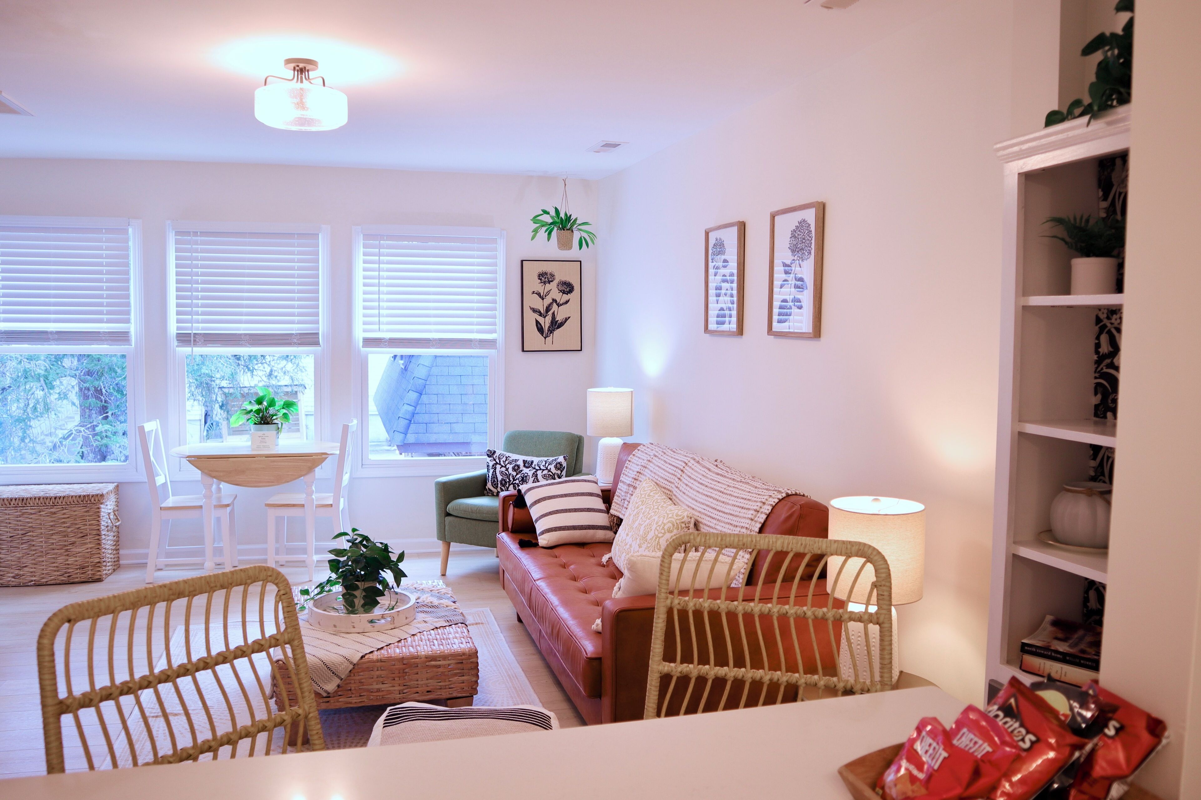 A cozy living room with a sofa, chairs, a table, and a bookshelf.