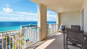 A balcony with a view of the ocean and buildings.