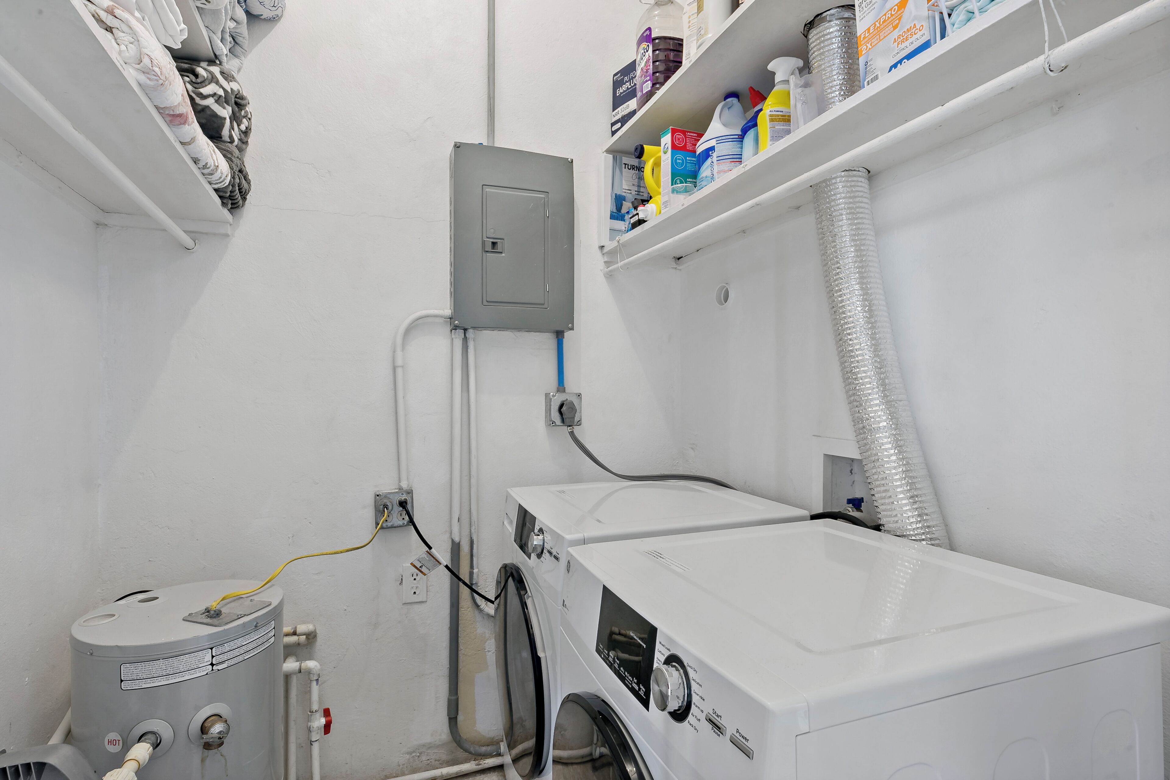 A laundry room with a washing machine, a utility meter, and a water heater.