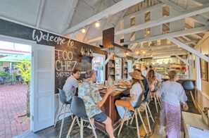 An indoor dining area with a bar, wooden beams, and a chalkboard sign.