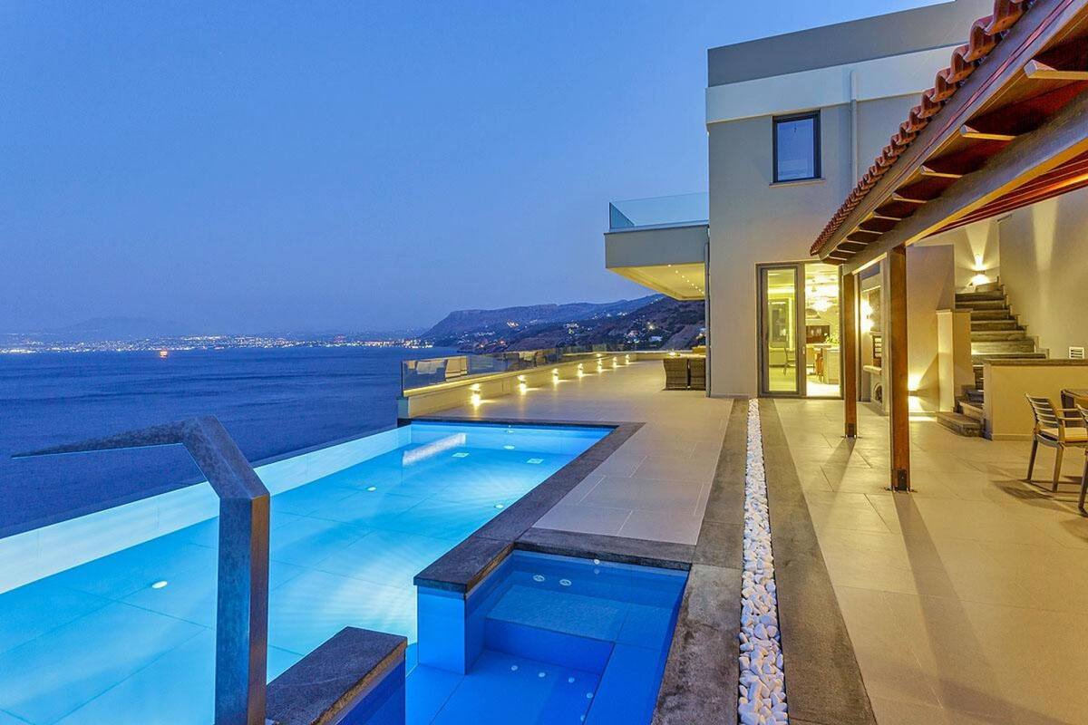A modern building with a swimming pool overlooking the sea.