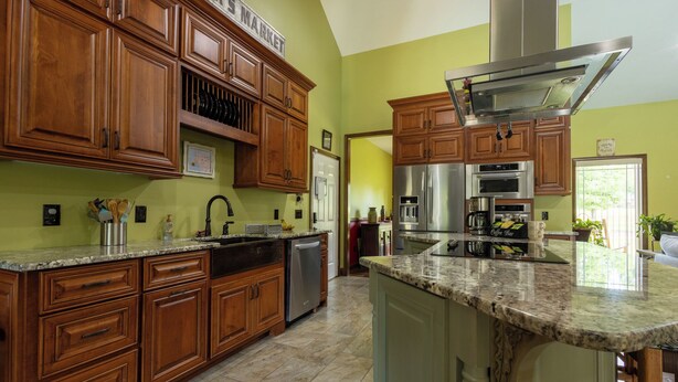 A kitchen with wooden cabinets, stainless steel appliances, and a granite countertop.