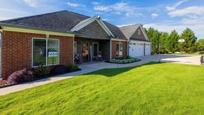 A two-story house with a brick facade, a stone entryway, and a garage.