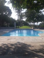 Una piscina rodeada de árboles y vistas al océano.