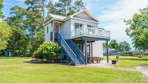 A two-story house with a balcony, a staircase, and a small porch area. - The Virginia Lee by Seaside Vacations & Sales (Chincoteague Island)