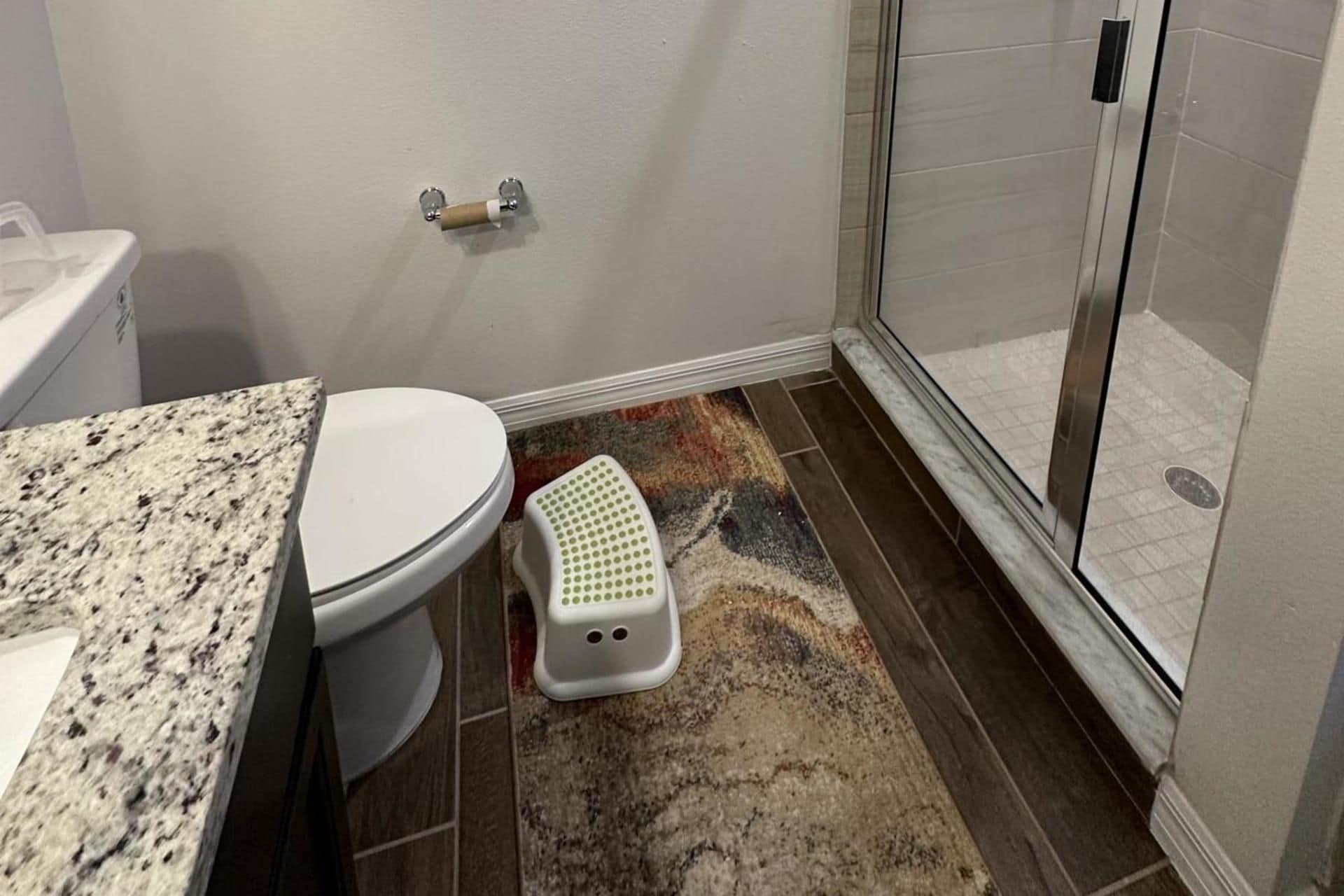 Un bagno con il water, una doccia e un tappeto sul pavimento.