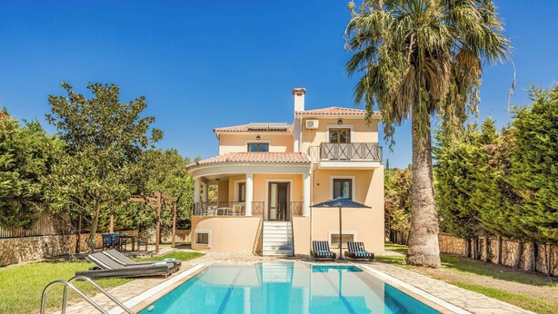Una casa de dos pisos con piscina, sillas de descanso y una pérgola.