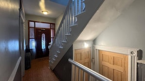 A staircase with a wooden handrail, a skylight, and a door with a window. - Huge 3 Bedrooms Apt 15 Minutes to NY City (West New York)