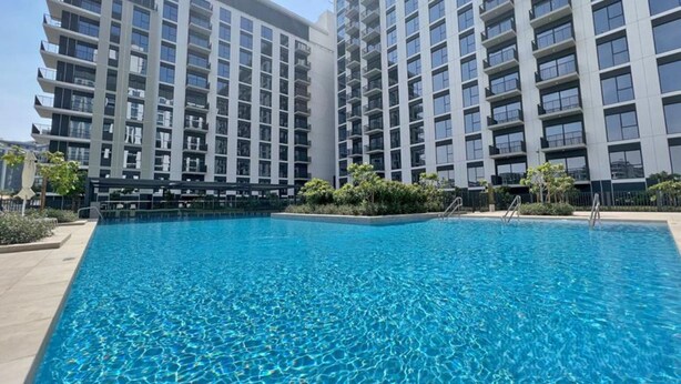 Un hotel moderno con una gran piscina rodeada de edificios altos.