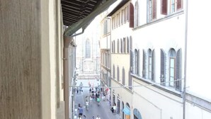 A narrow street with buildings on both sides, featuring arched windows and a mix of architectural styles. - A Pochi Metri dal Duomo! (Firenze)