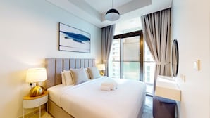 A modern hotel room with a large bed, a bedside table with a lamp, a wall-mounted artwork, and a view of the outside through a large window. - Elegant 2 Bed| Business Bay | Central & Convenient - Aykon City Tower (Business Bay)