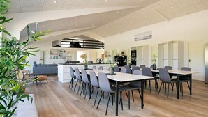 A spacious, modern dining area with a central island, surrounded by multiple tables and chairs. - 22 Person Holiday Home in Lokken-by Traum (Lokken)