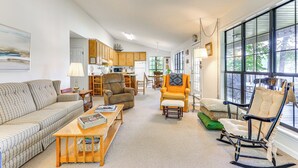 A spacious living room with a sofa, armchairs, and a rocking chair. There is a dining area with a table and chairs, and a kitchen in the background. - Waterfront Wheeler Lake Home w/ Furnished Deck (Athens)