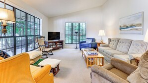 A spacious living room with large windows, a television, and various seating options. - Waterfront Wheeler Lake Home w/ Furnished Deck (Athens)