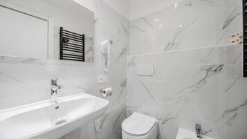 A modern bathroom with a white sink, a toilet, and a bidet.