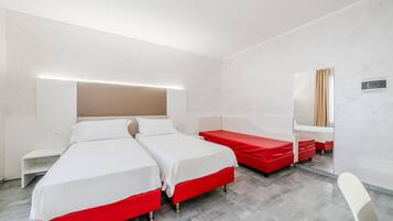A hotel room with two beds, a desk, and a mirror.